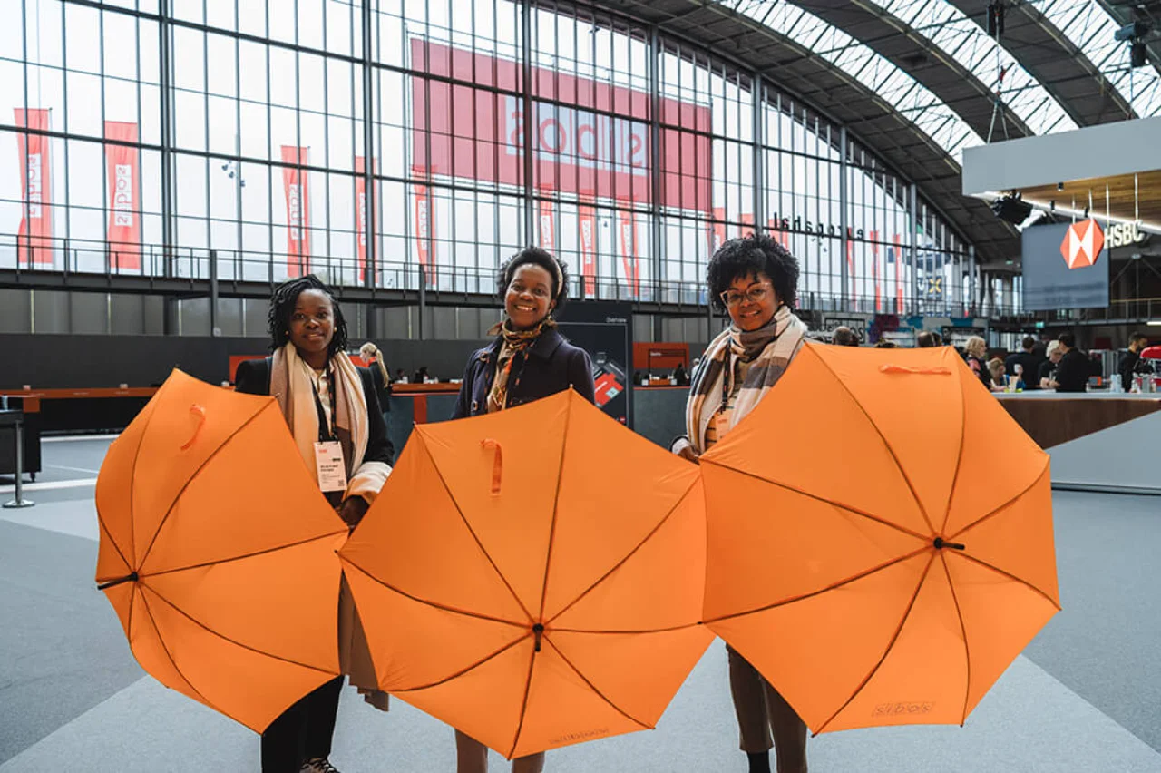 Women holding umbrellas at Sibos
