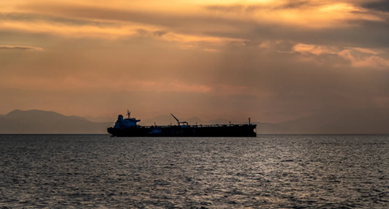 Crude oil tanker in the sea at fiery sunset