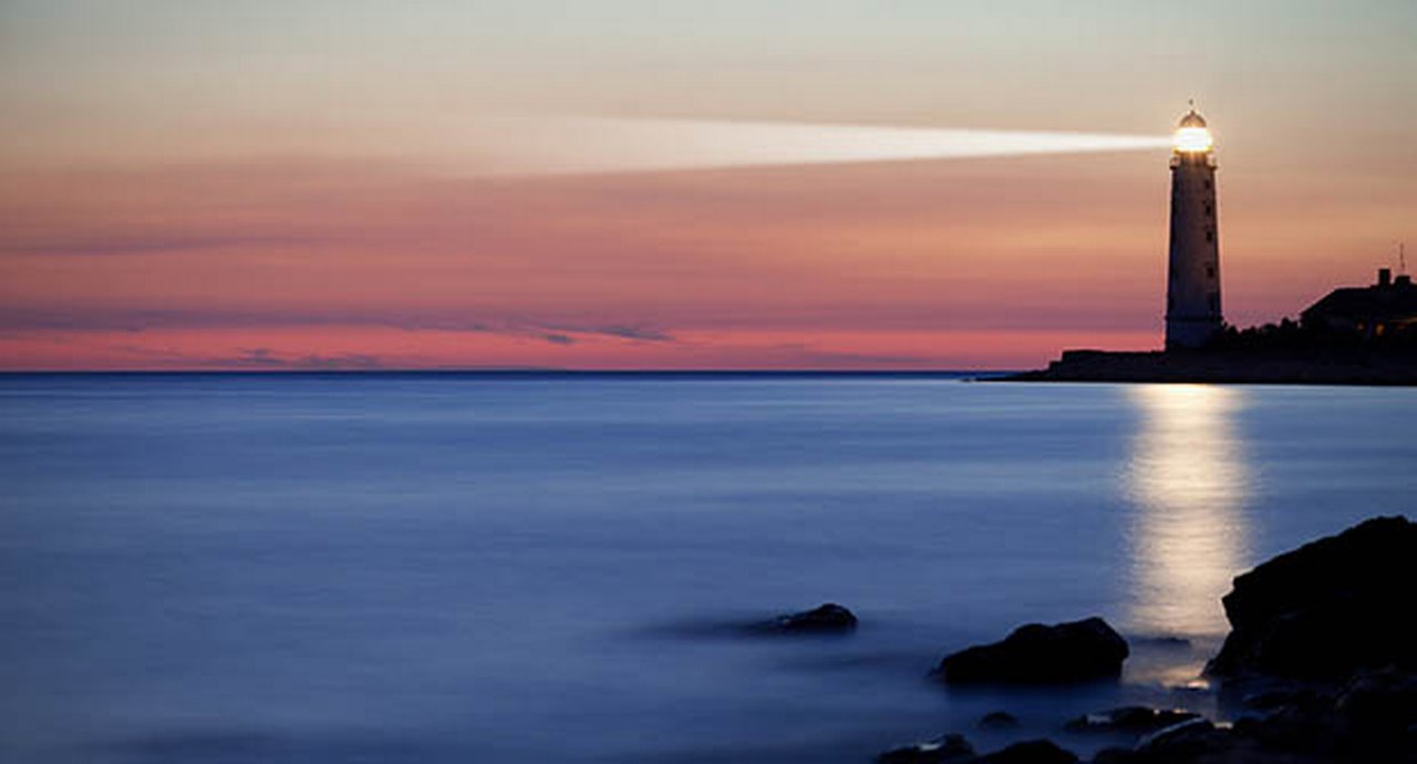 A lighthouse on the coast during dusk