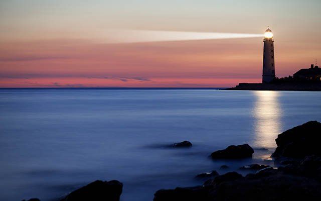 A lighthouse on the coast during dusk