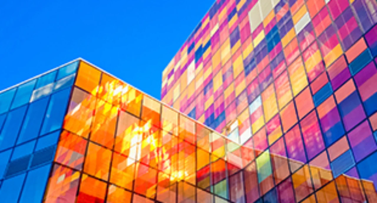 Two glass skyscrapers mirorring a myriad of colours