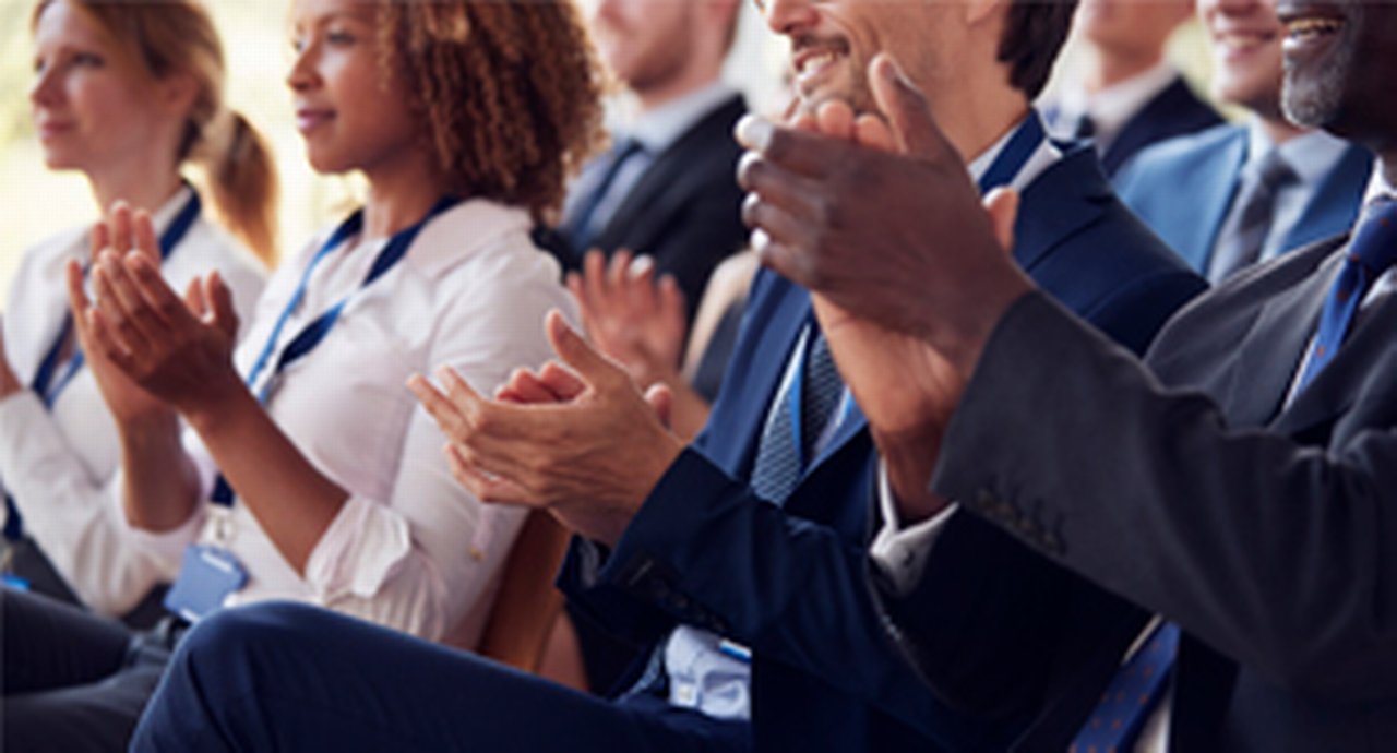 An excited diverse audience clapping
