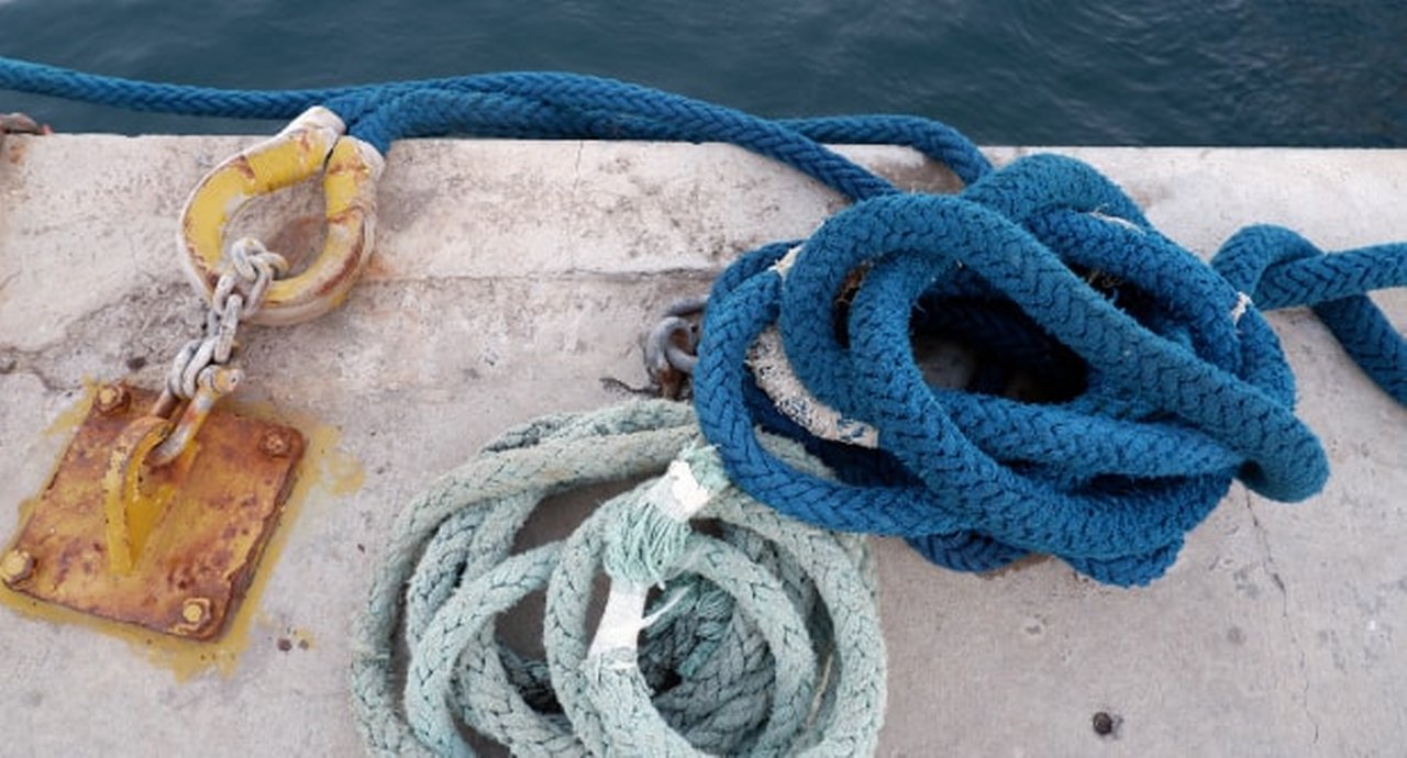 Close Up Image Of Blue Ropes Lying On The Concrete Deck Of Pier At Sea Coast