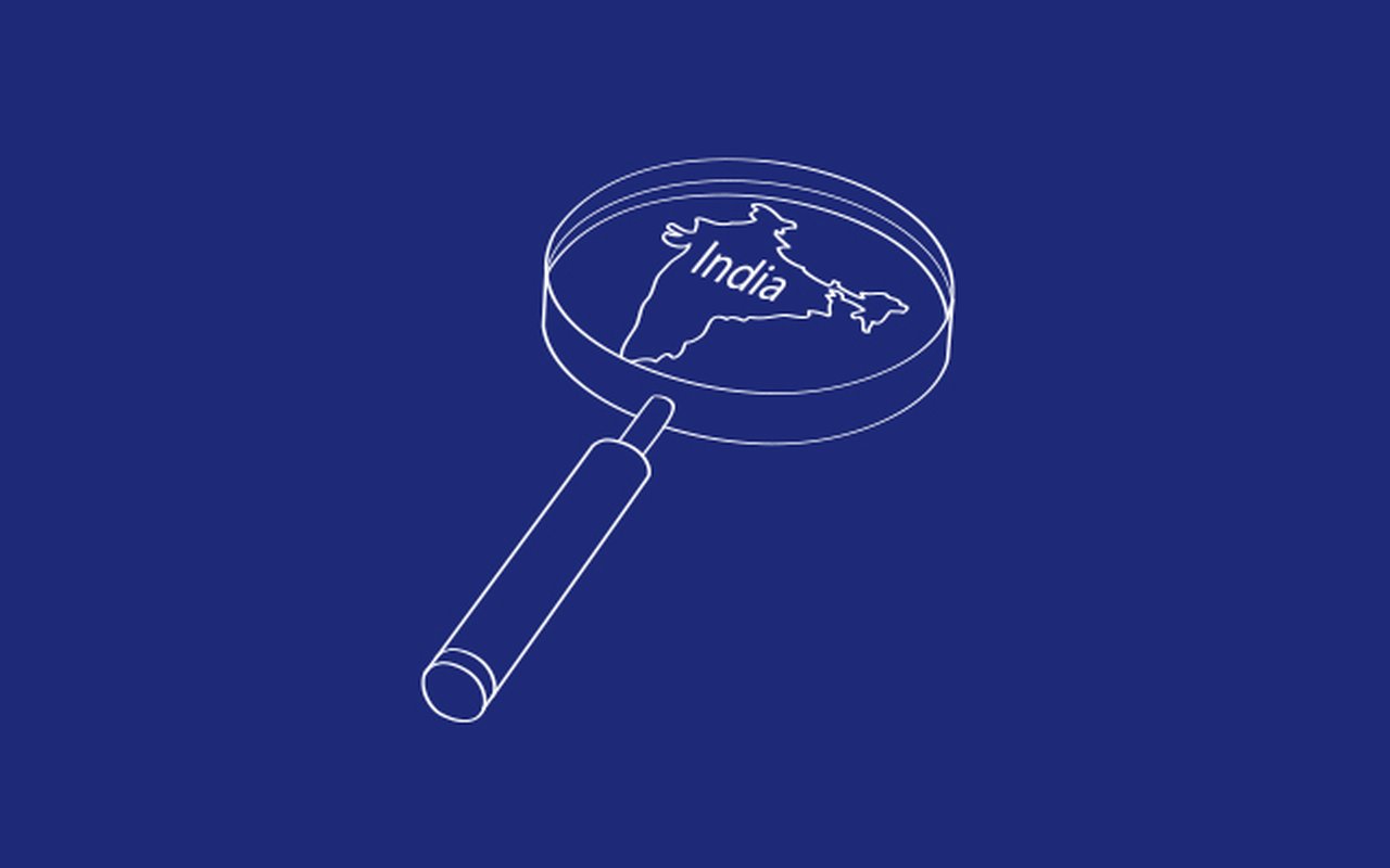 schematically illustrated magnifying glass on dark blue background with focus on India