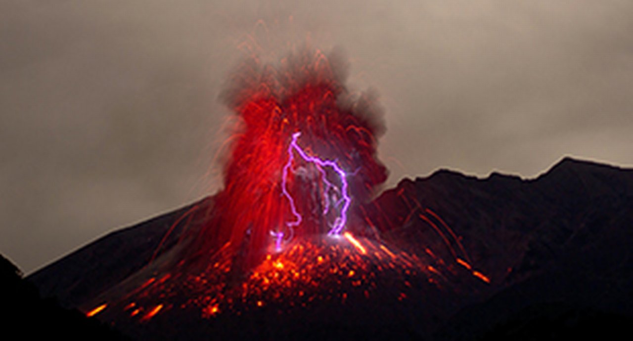 An erupting volcano in vivid red and with magenta lighting