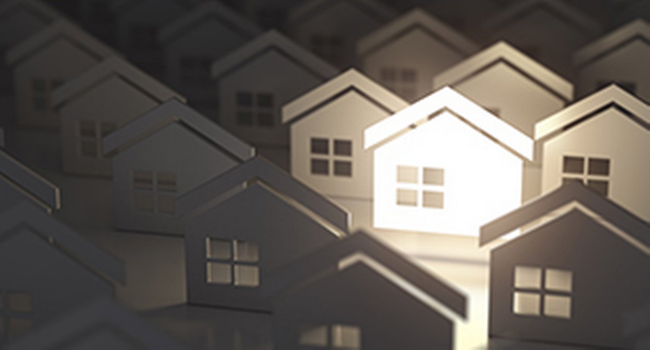 paper silhouettes of houses with one house illuminated