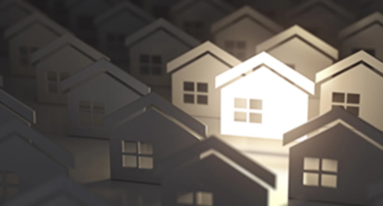 paper silhouettes of houses with one house illuminated