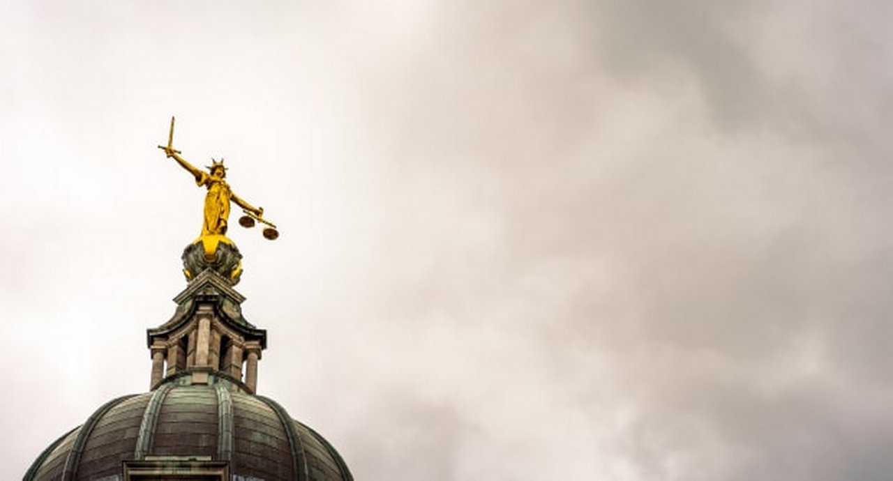 lady justice facing a stormy sky