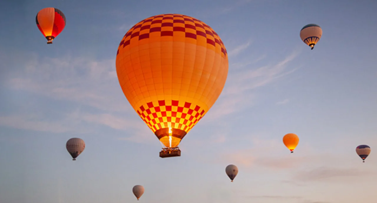 Hot Air Balloons Ascend At Sunrise Over A Scenic Landscape