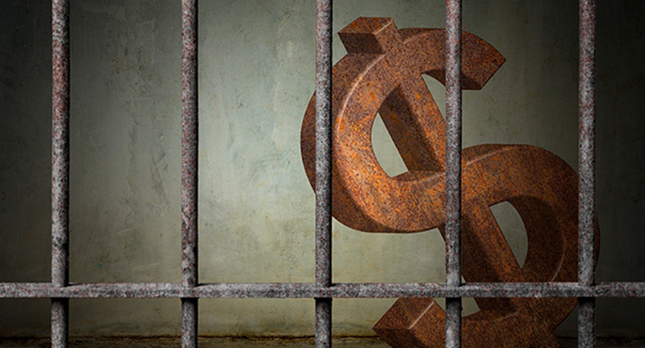 large rusty dollar sign is imprisoned in old prison