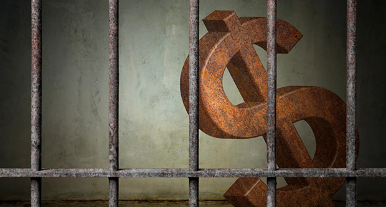 large rusty dollar sign is imprisoned in old prison