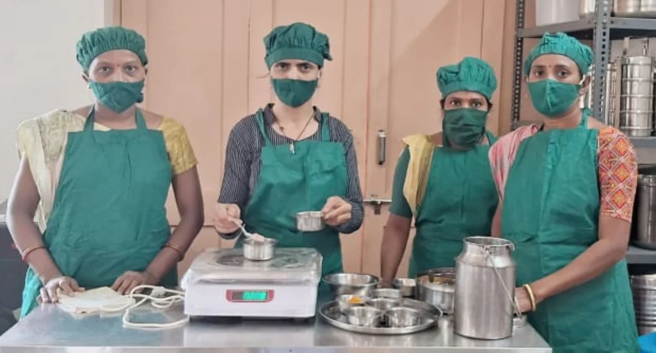 Four Kamla co-operative members wearing green protective clothing