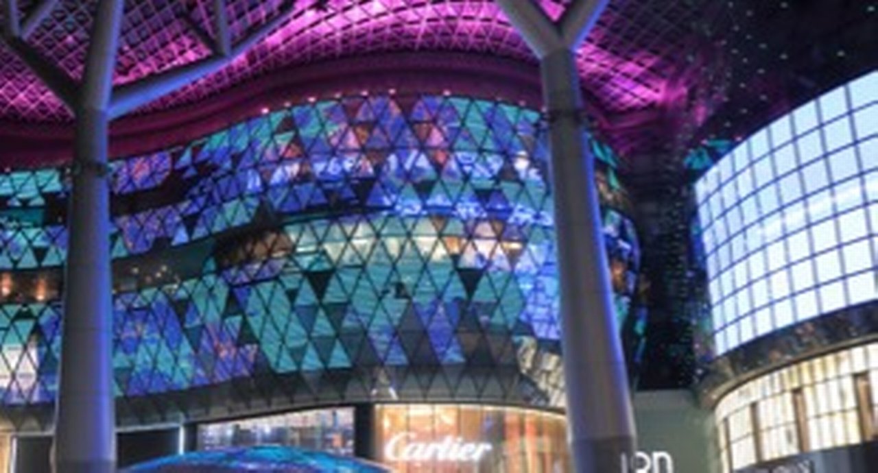 Tourists and local people visit ION Orchard department store by night in Orchard Road shopping district Singapore