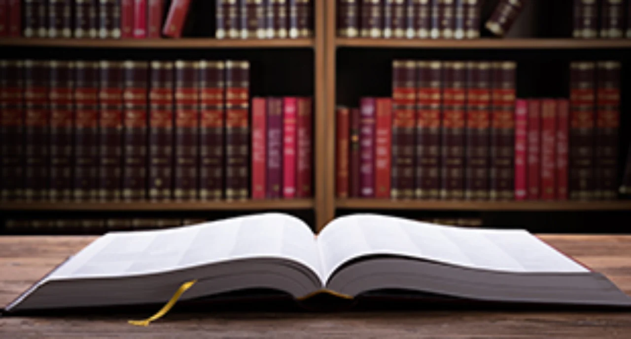 Close-up Of An Open Law Book On Wooden Desk In Courtroom