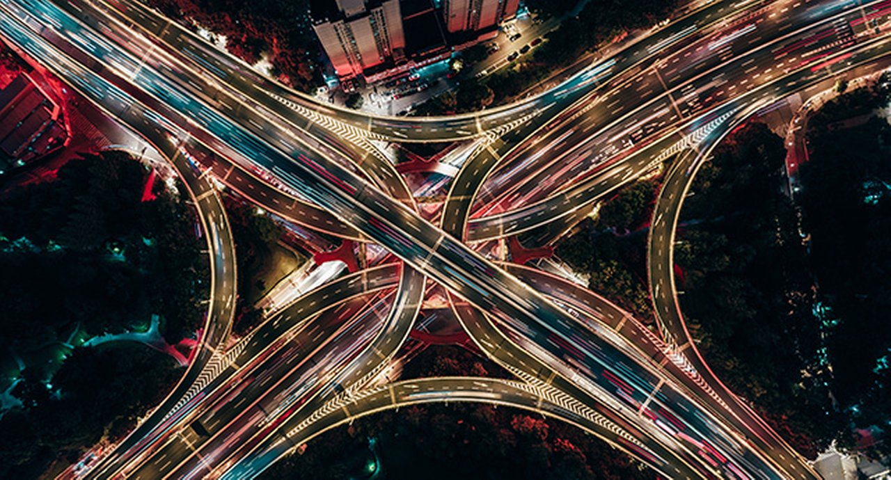 Drone aerial view of an overpass and city traffic at night