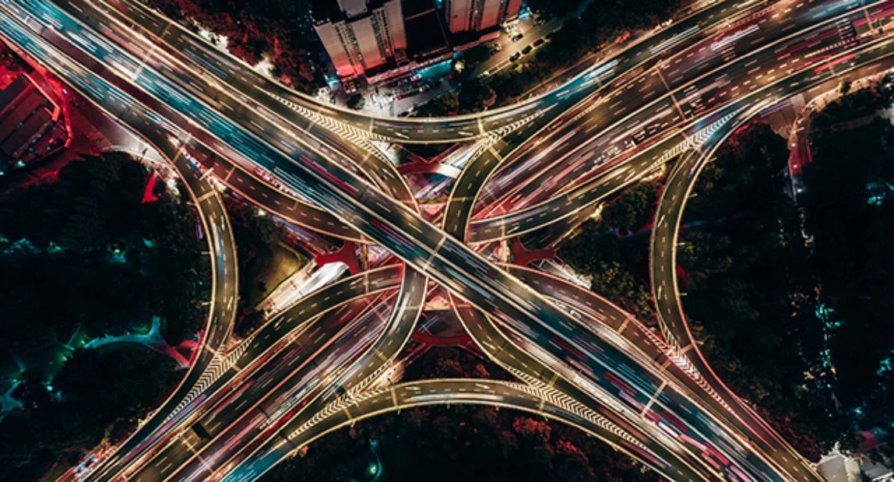 Drone aerial view of an overpass and city traffic at night
