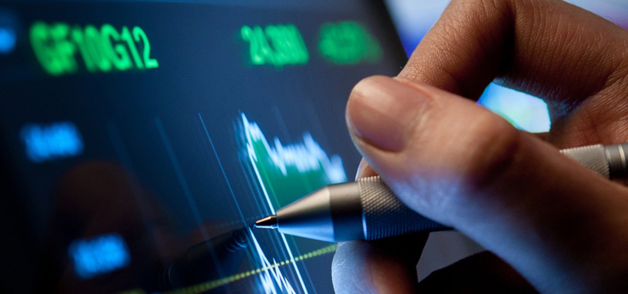 Hand holding a digital pen while writing on a screen