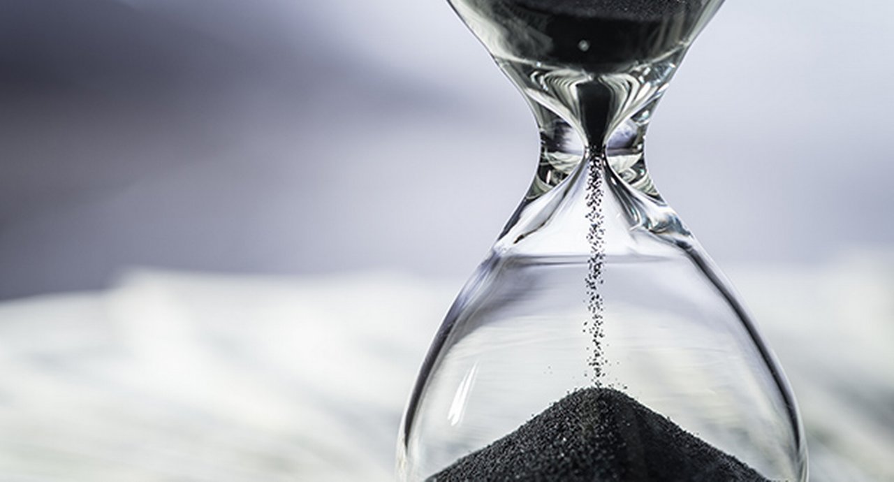 Closed Up Of Sand Falling In Sandglass Or Hourglass On Us Dollar Bills