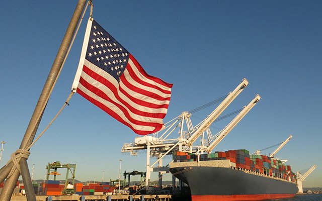 American flag next to a port container ship
