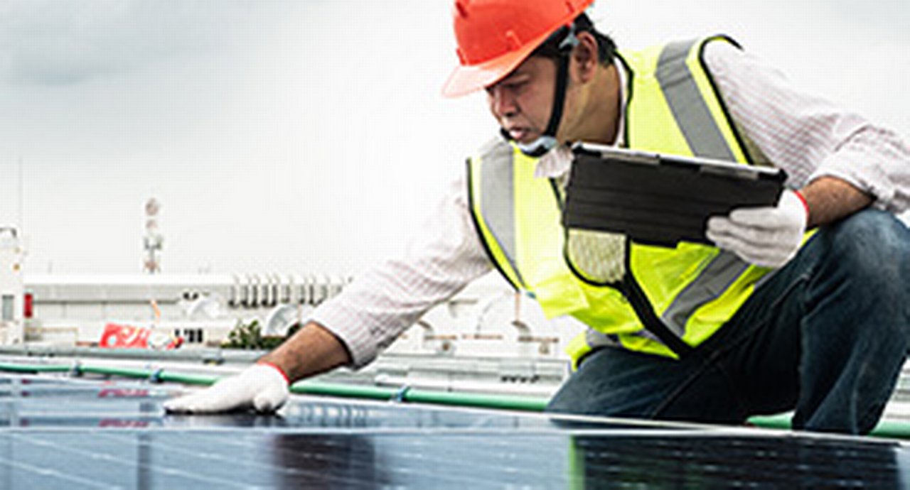 Male engineer checks a photovoltaic (solar) plant and uses a recording