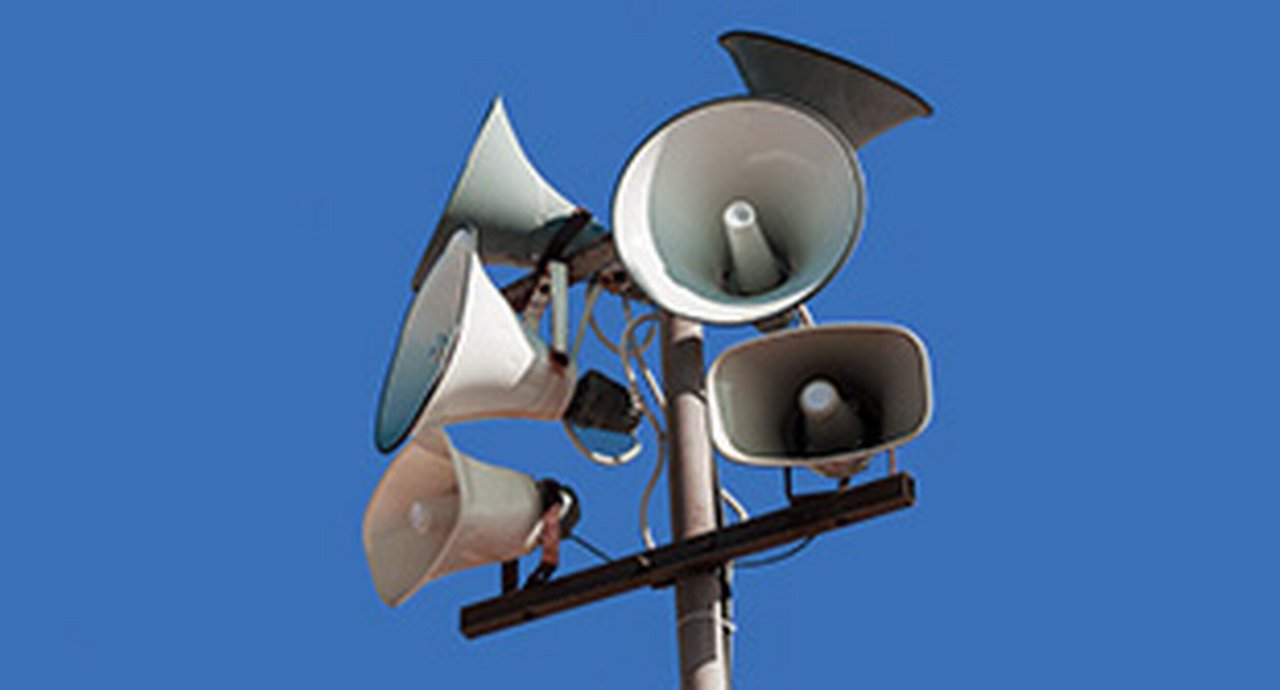 Set of street loudspeakers on a pole on background blue sky