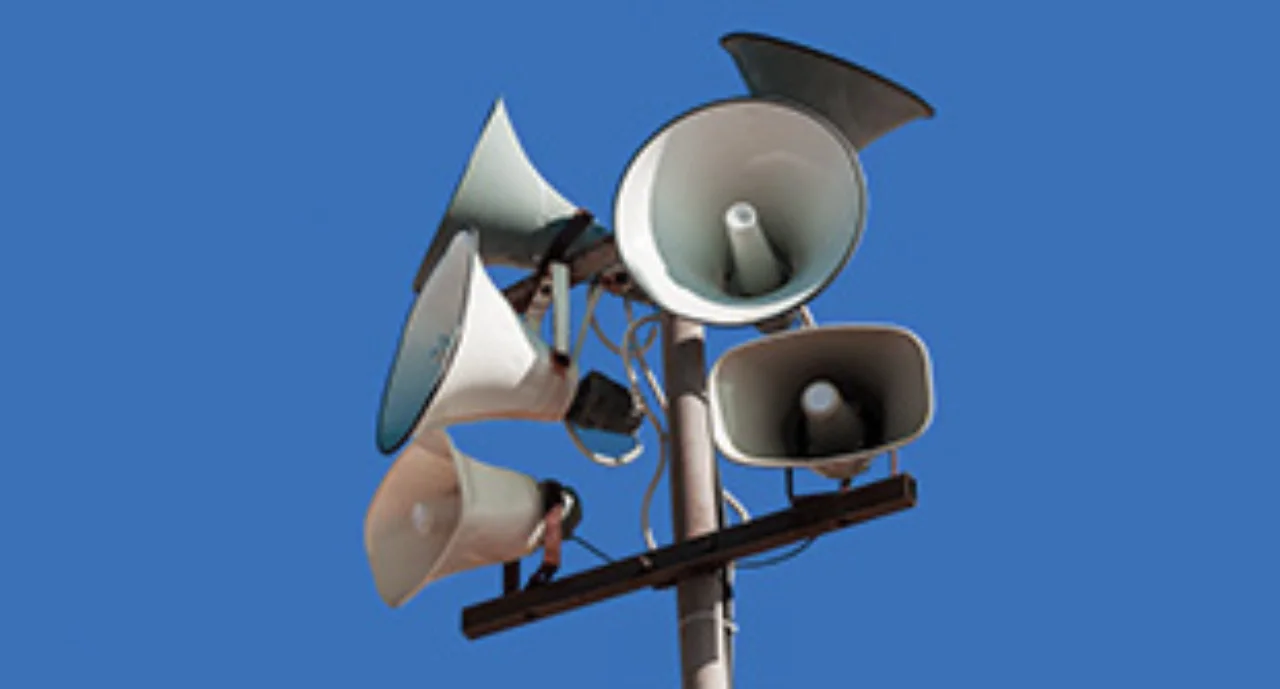 Set of street loudspeakers on a pole on background blue sky