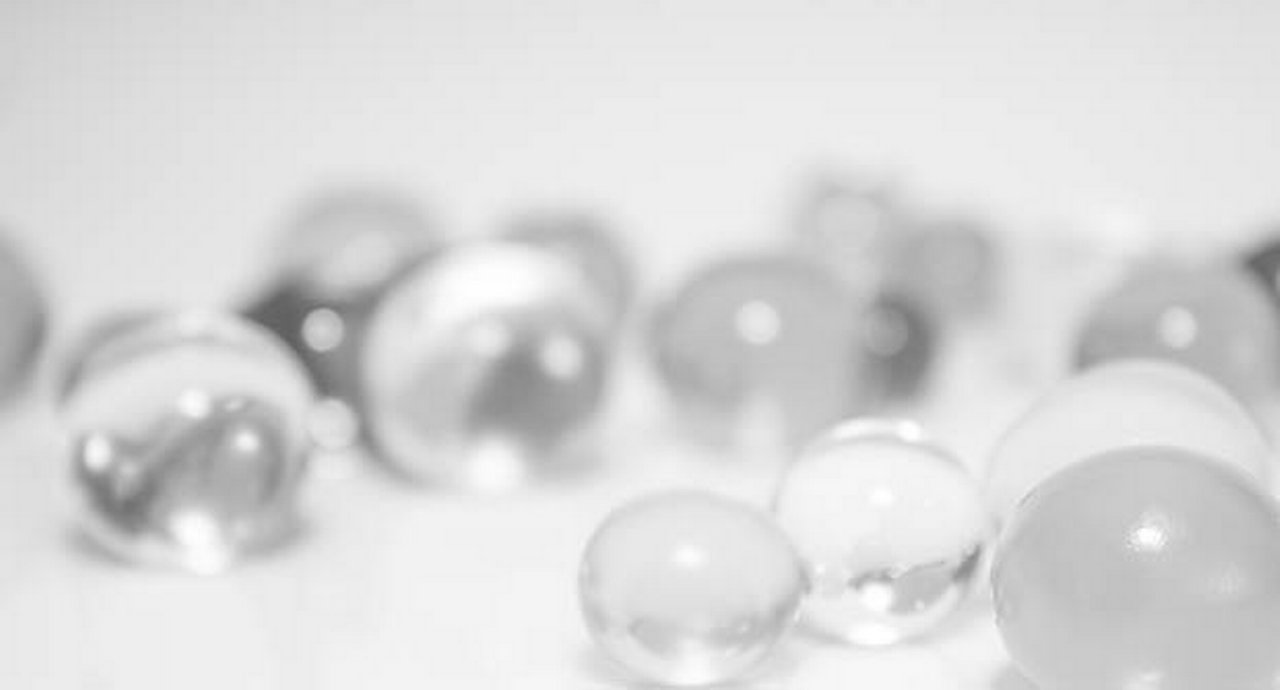 Clear glass marbles on a white surface bathed in light