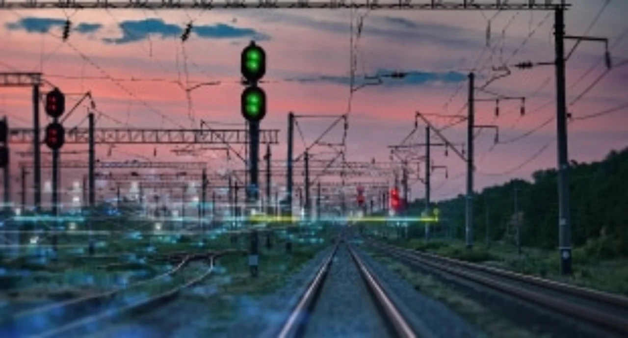 Train tracks, lights, and cables in the sunset