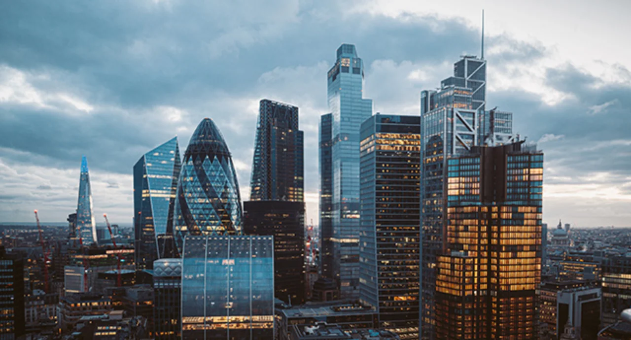 Aerial panoramic view of The City of London with modern skyscrapers after sunset on night with illuminated buildings