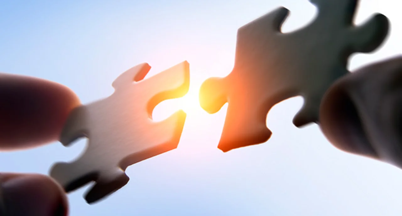 Putting puzzle pieces together on sky background with sunlight