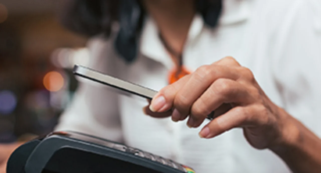 Close-up of a woman paying with her smartphone at a card machine