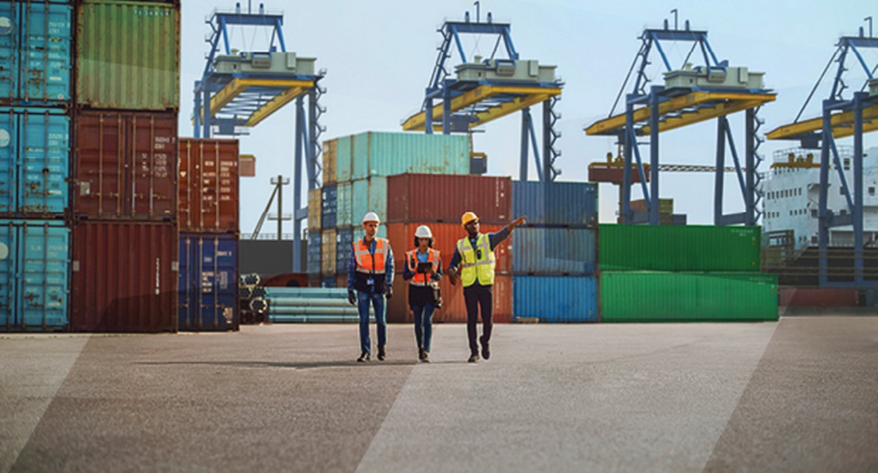 Three dock workers amoung containers