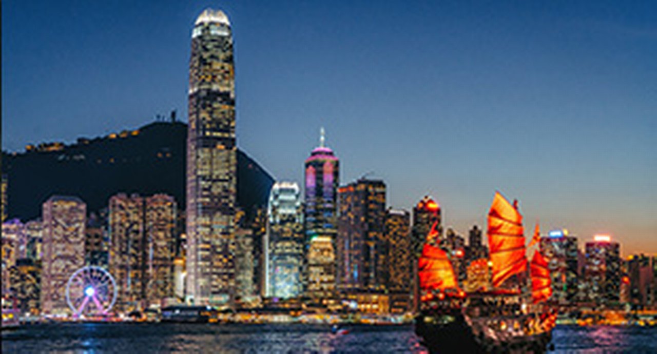 Victoria Harbour at night with brightly illuminated skyscrapers in the background