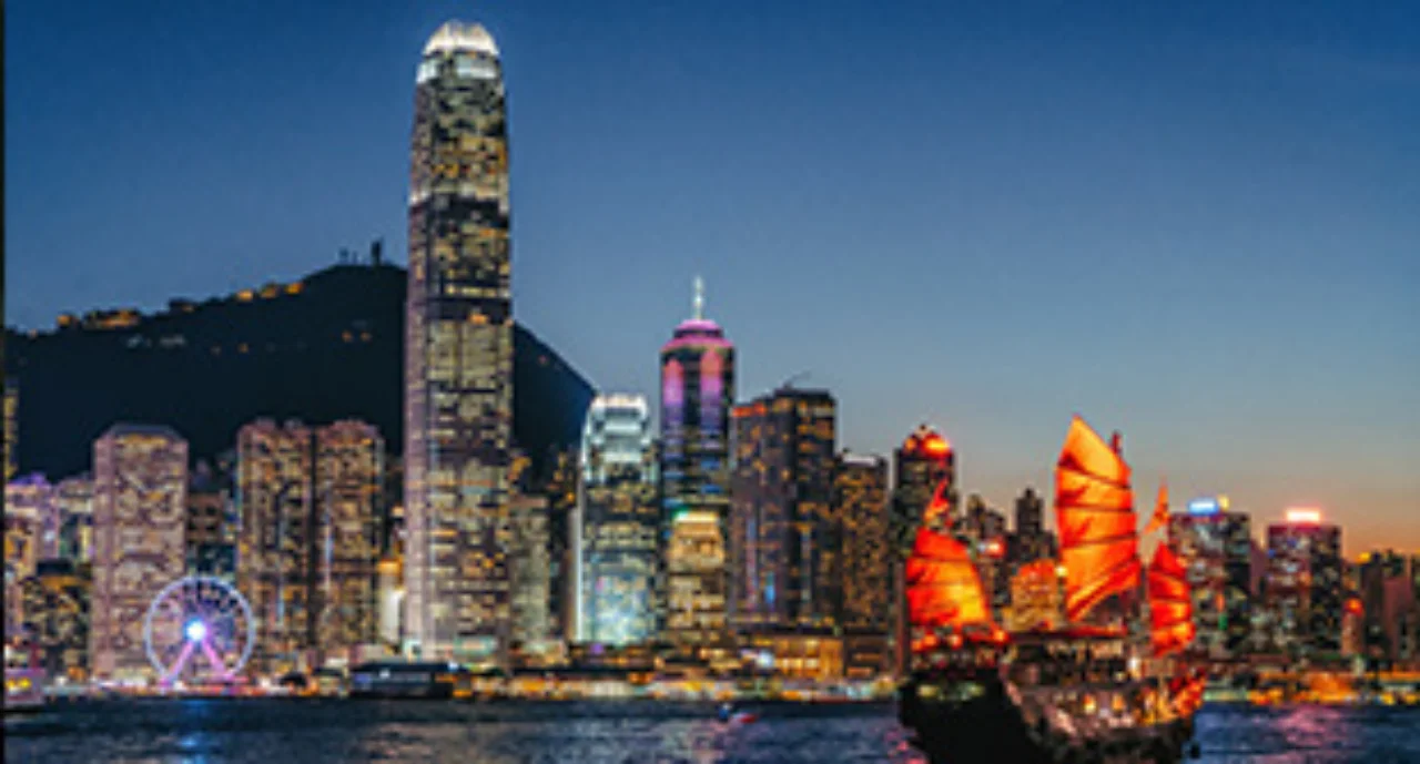 Victoria Harbour at night with brightly illuminated skyscrapers in the background