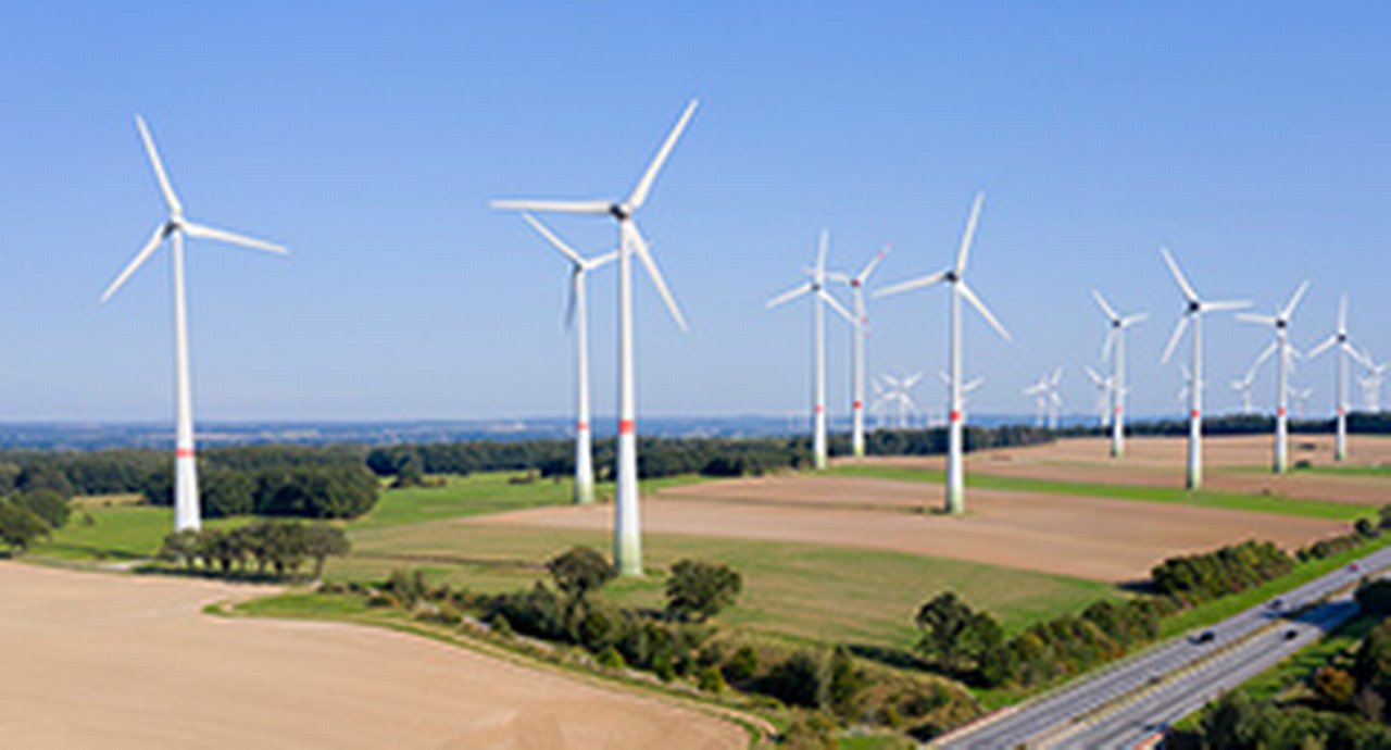 Renewable energy plant - wind turbine farm near the highway, aerial view