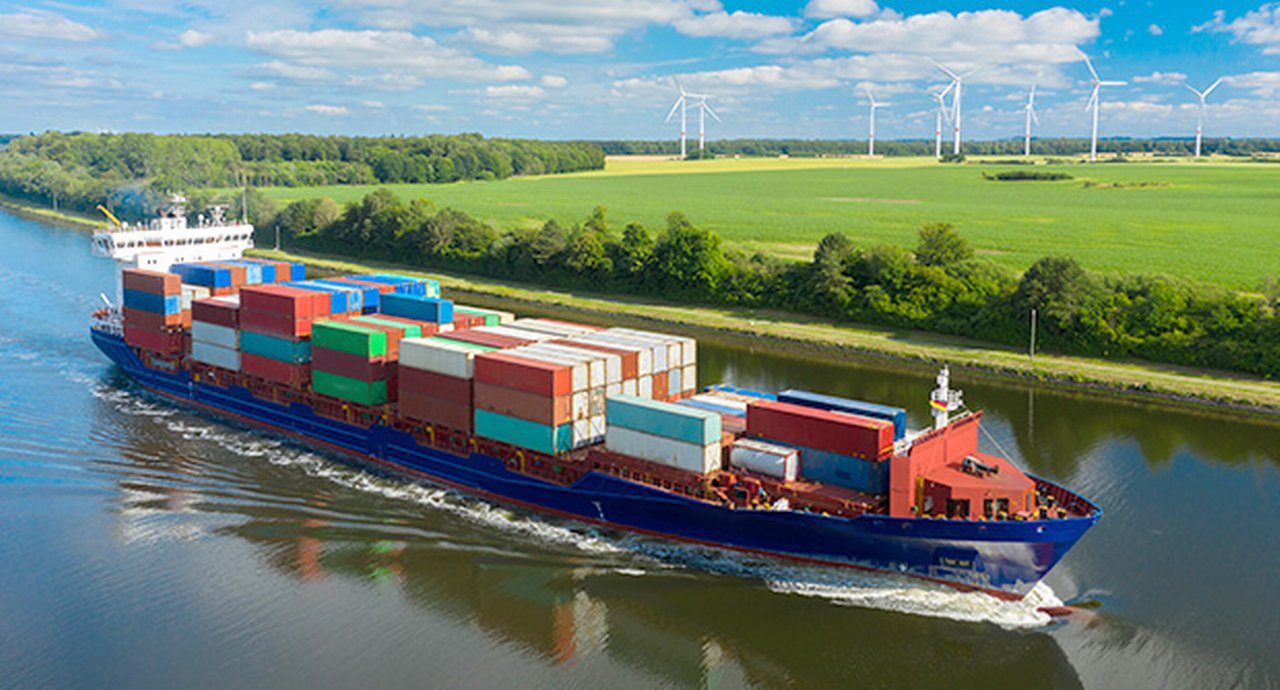 Container Ship On The Kiel Canal And Windmill On The Background