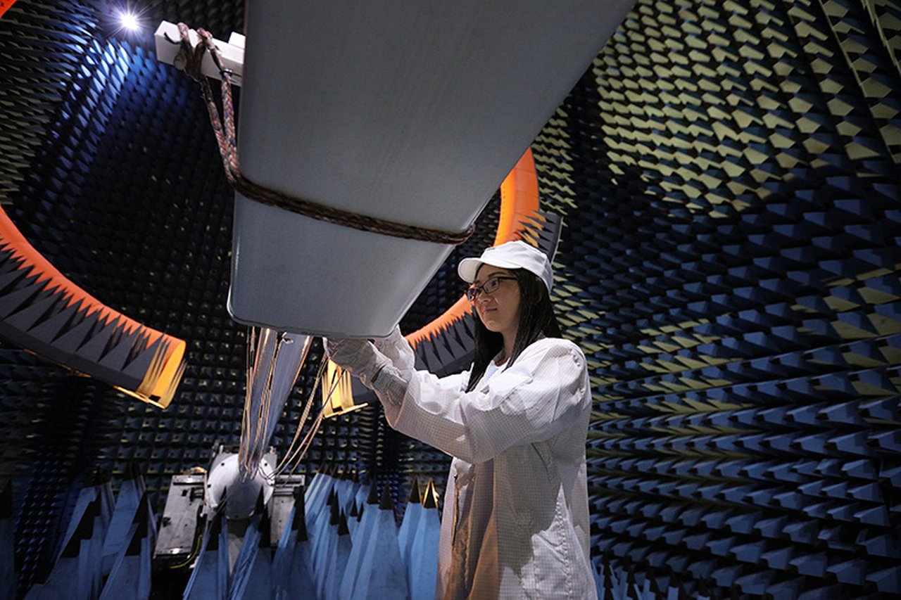 Huawei employee carries out quality checks on a cell network antenna