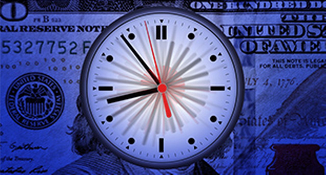 A clock in front of a hundred dollar bill