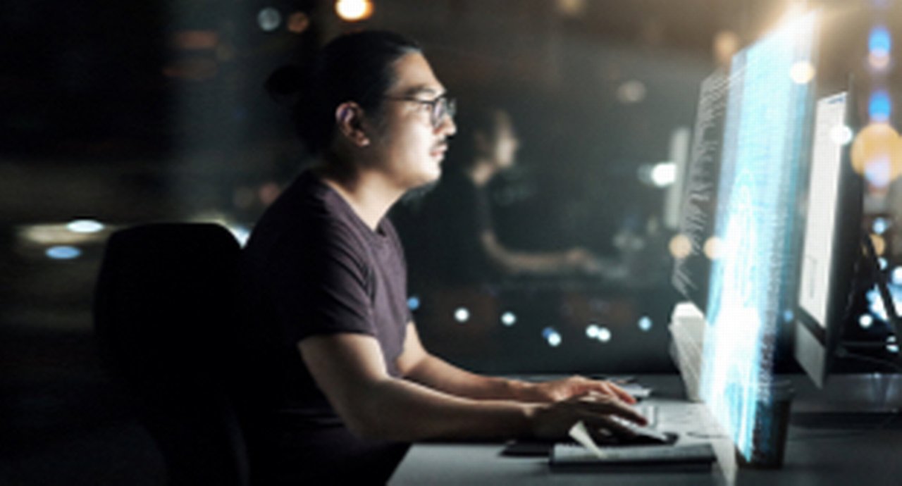 A young man working concentrated at his computer terminal