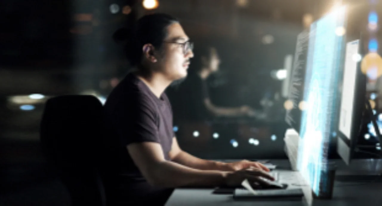 A young man working concentrated at his computer terminal