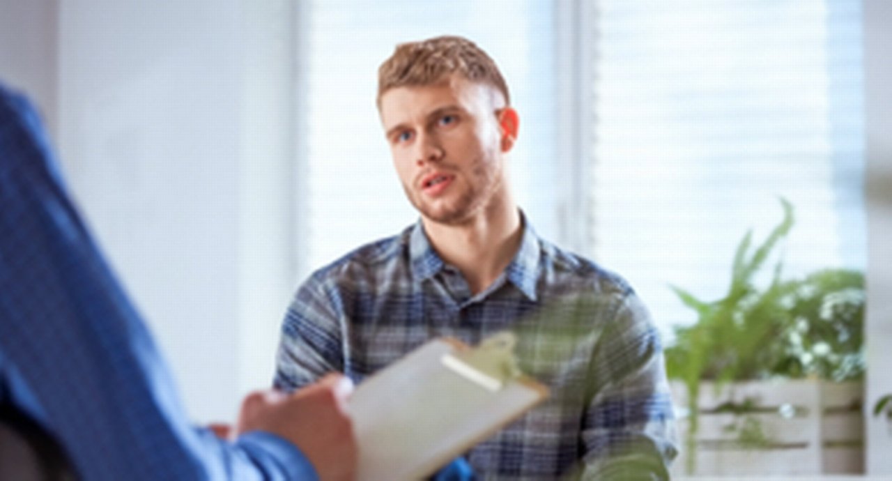 A young white man being consulted and listening intensely
