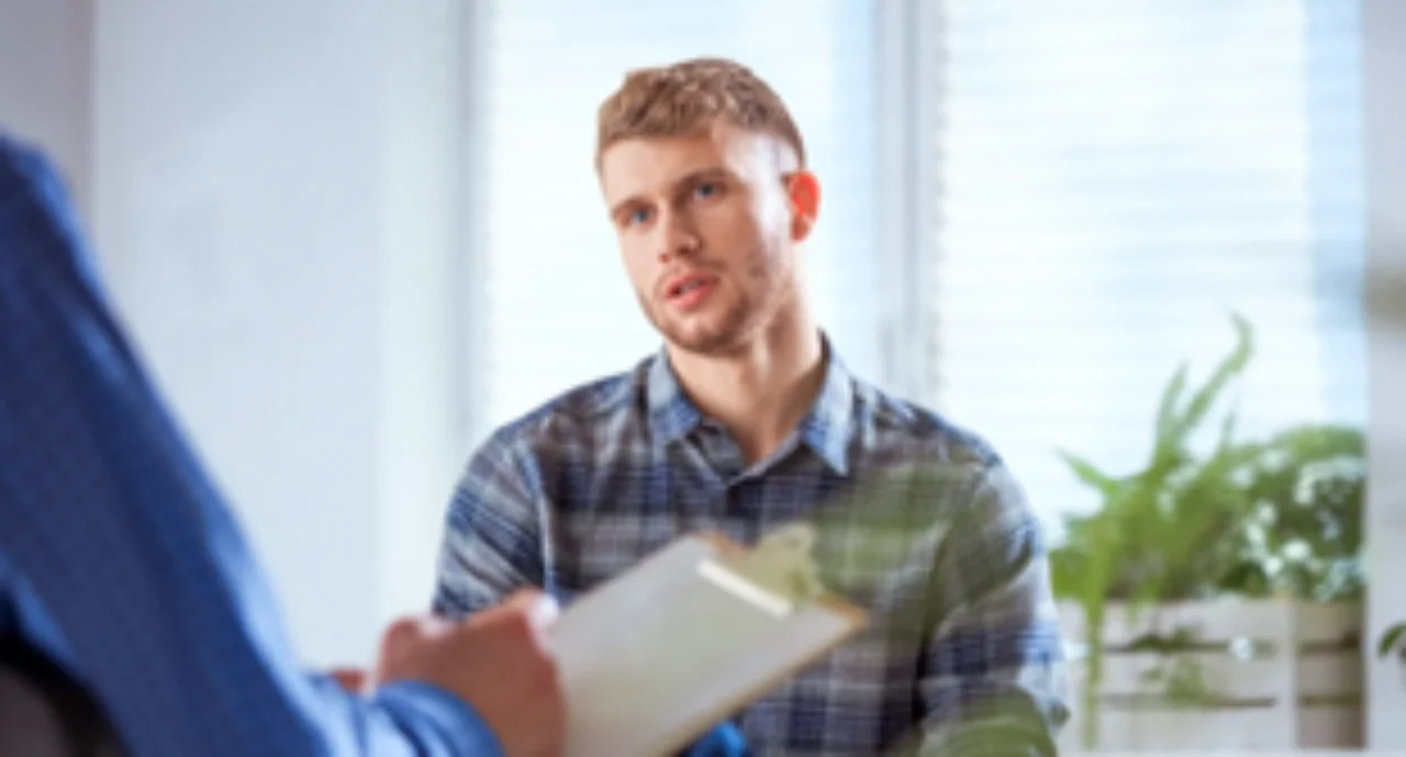 A young white man being consulted and listening intensely