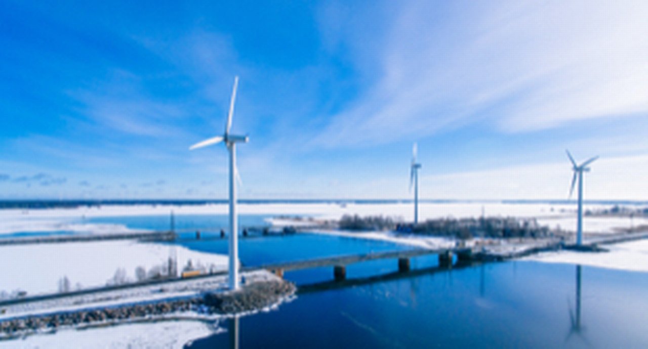 Aerial view of windmills with blue frozen river in snow winter Finland
