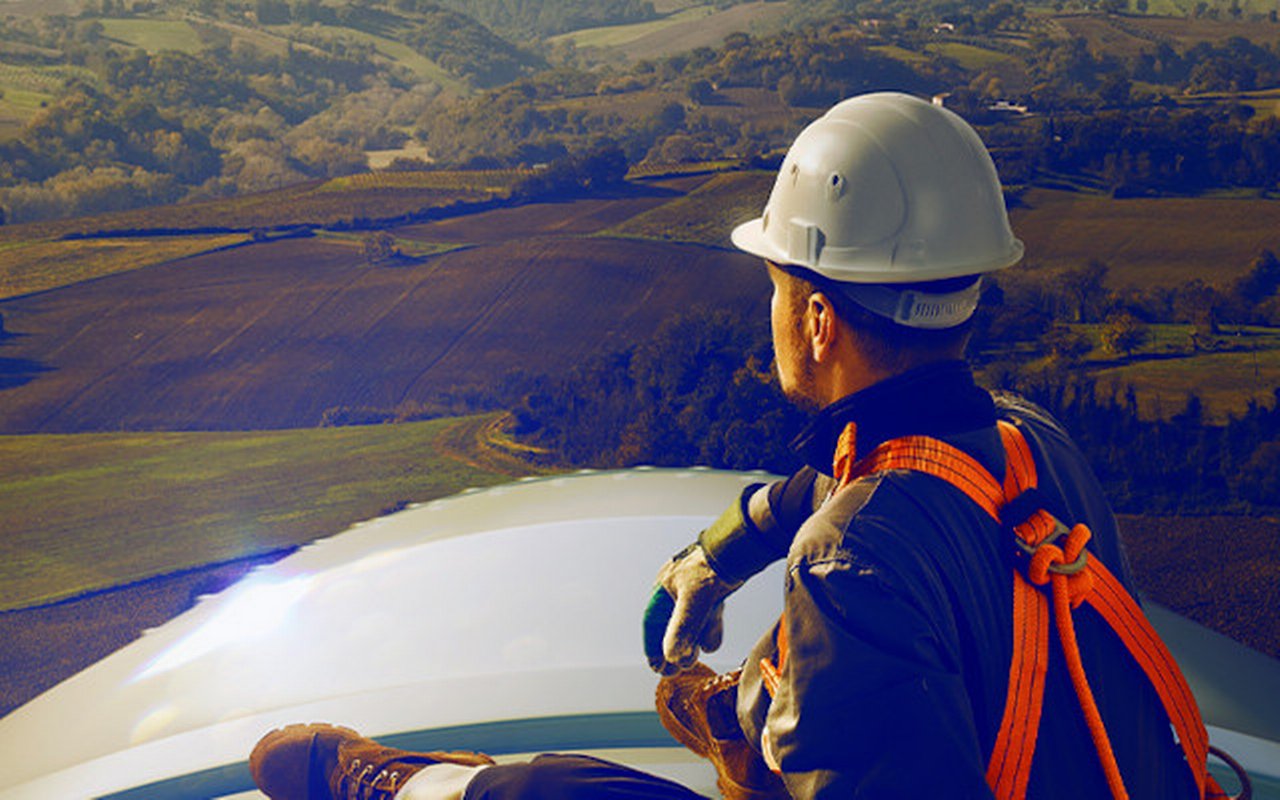 Service worker sitting on a wind turbine