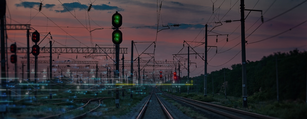 Train tracks, lights, and cables in the sunset