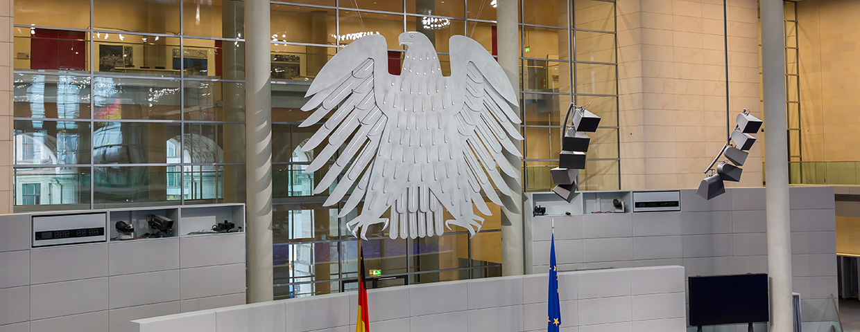 View on interior of the empty plenary hall of the German Federal Parliament (Deutscher Bundestag). In the middle the german coat of arms (eagle, so-called Bundesadler)