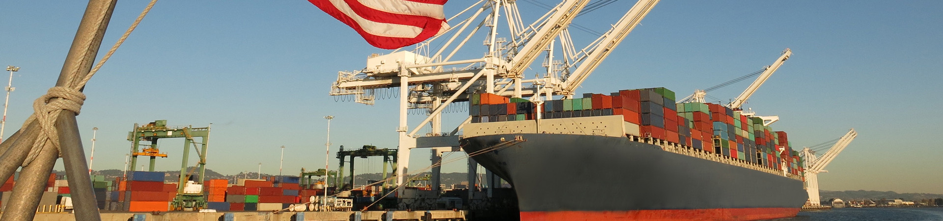 American flag next to a port container ship