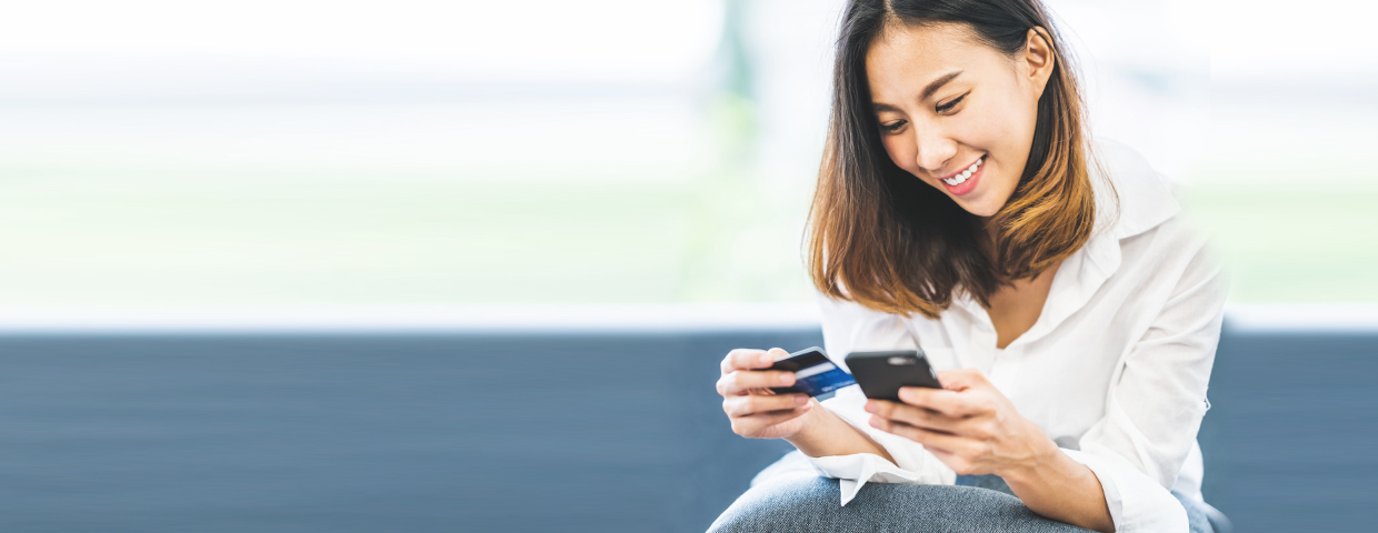 young asian woman using smartphone and credit card for online shopping