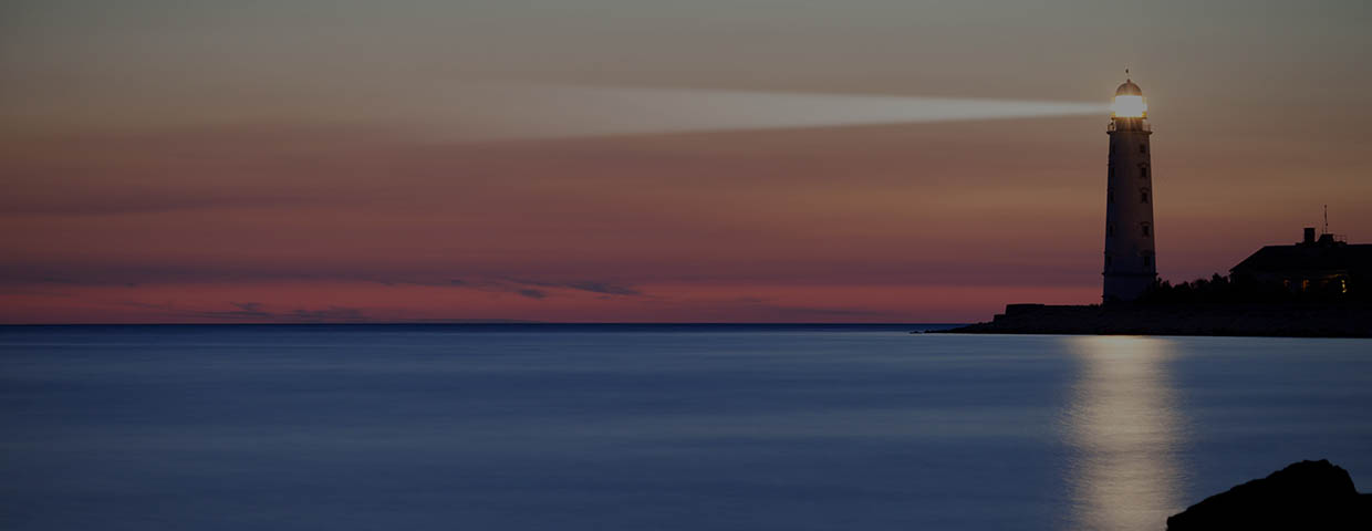 A lighthouse on the coast during dusk