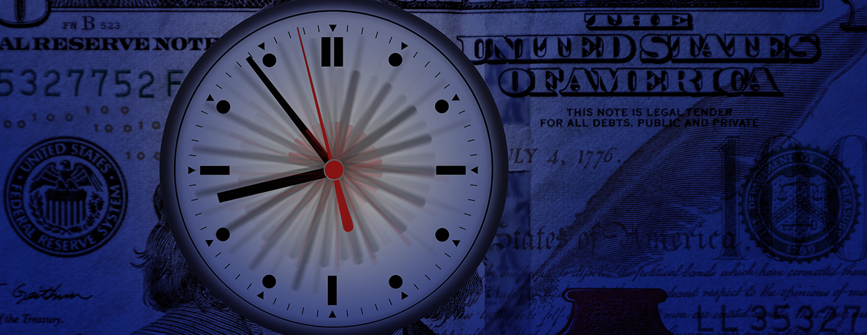 A clock in front of a hundred dollar bill